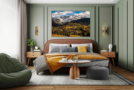 A bedroom with green walls and a large Telluride Fall painting by Shestakov Fine Art on the wall.