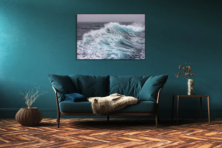 A living room with a Drake Passage painting by Shestakov Fine Art on the wall and a couch.